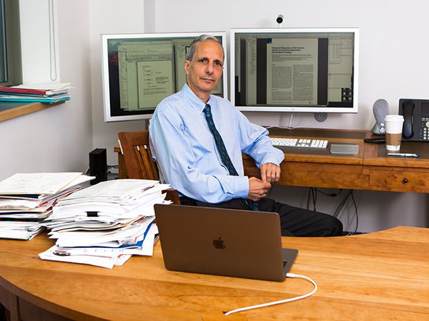 Doctor Robert Darnell sits behind his desk at the New York Genome Center