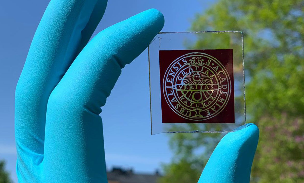 A researcher holds a dye-sensitized solar cell based on a copper iodide complex.