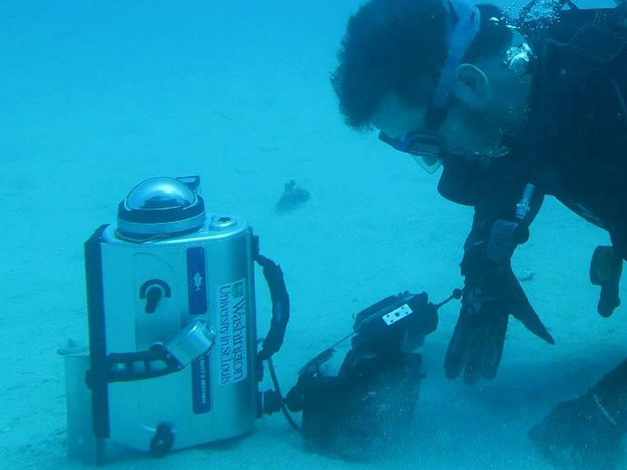 A diver uses the underwater polarization camera with fish-eye lens.