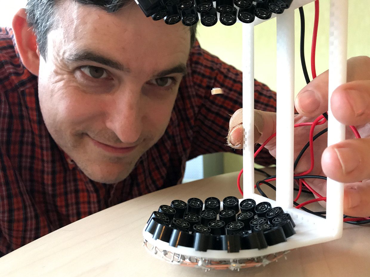 Photo of Stephen Cass holding the mounted 72 ultrasonic transducers in a 3D-printed frame.