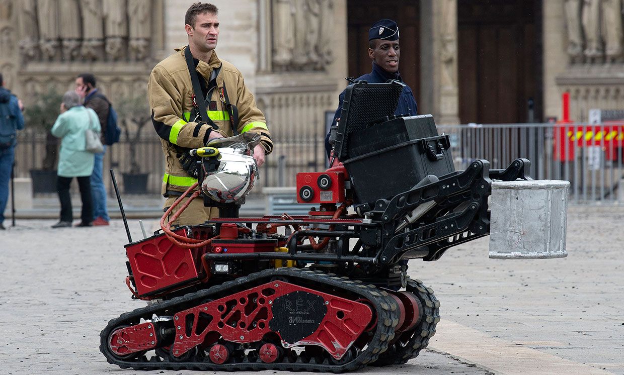 Firefighters are seen with a robot firefighter called Colossus, made by French robotics company Shark Robotics, outside Notre-Dame Cathedral on April 16, 2019 in Paris, France.