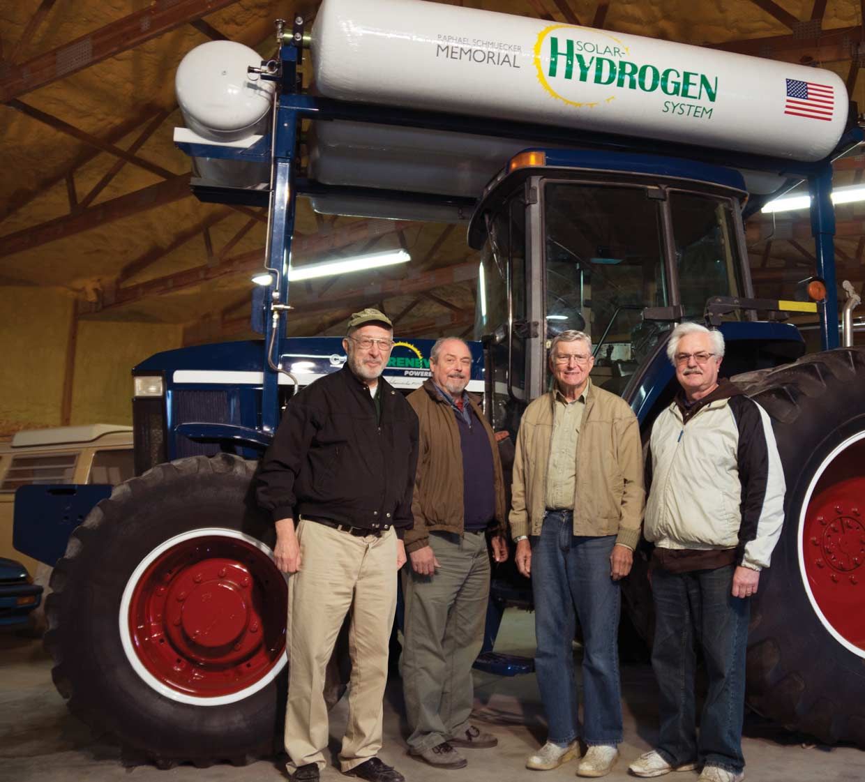 Four men standing in front of a tractor.