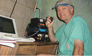 Image of Loring Kutchins holding a microphone connected to a transmitter. 
