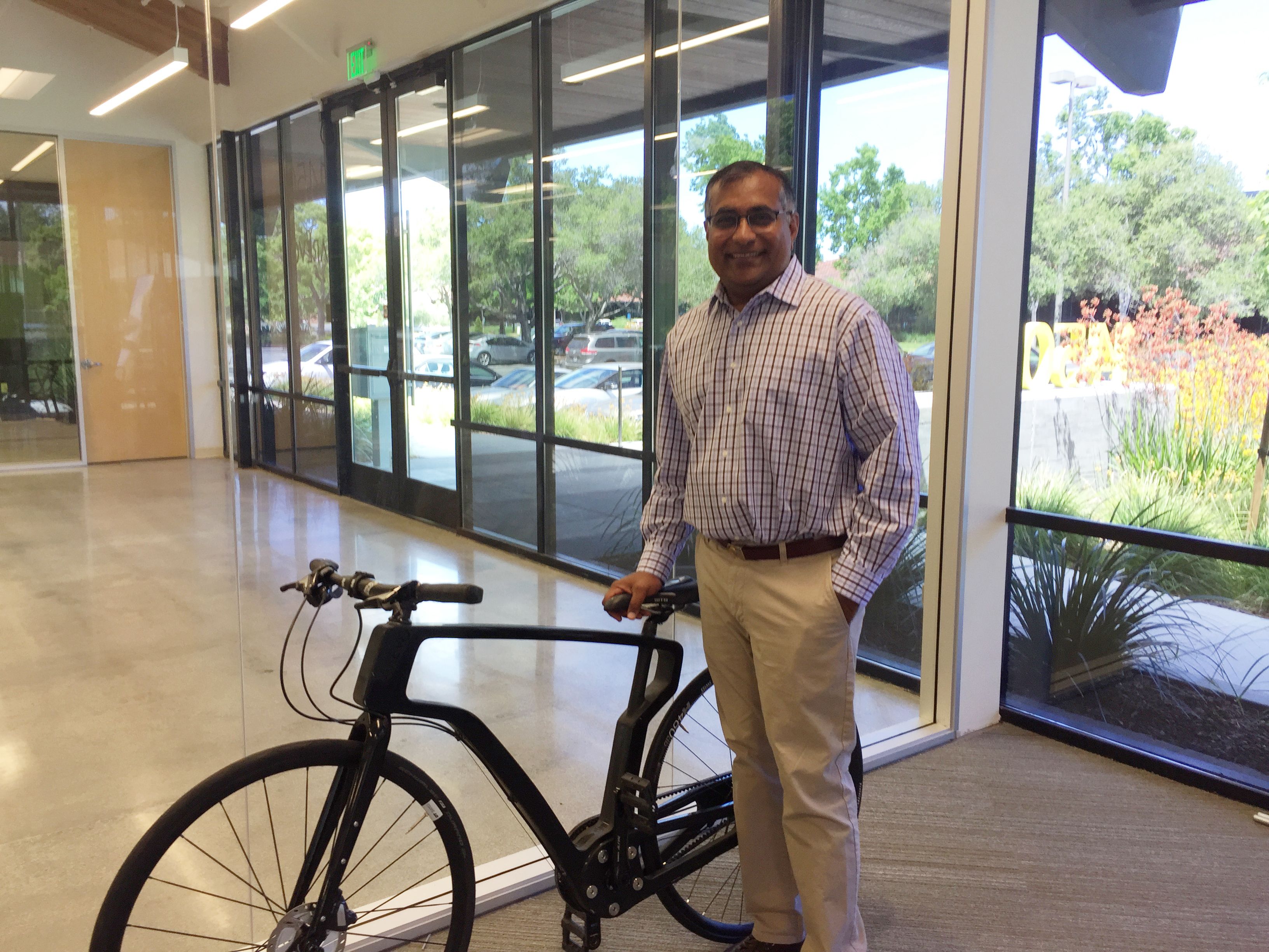 Image of Bheda in front of the bike with a 3D-printed carbon fiber composite frame.