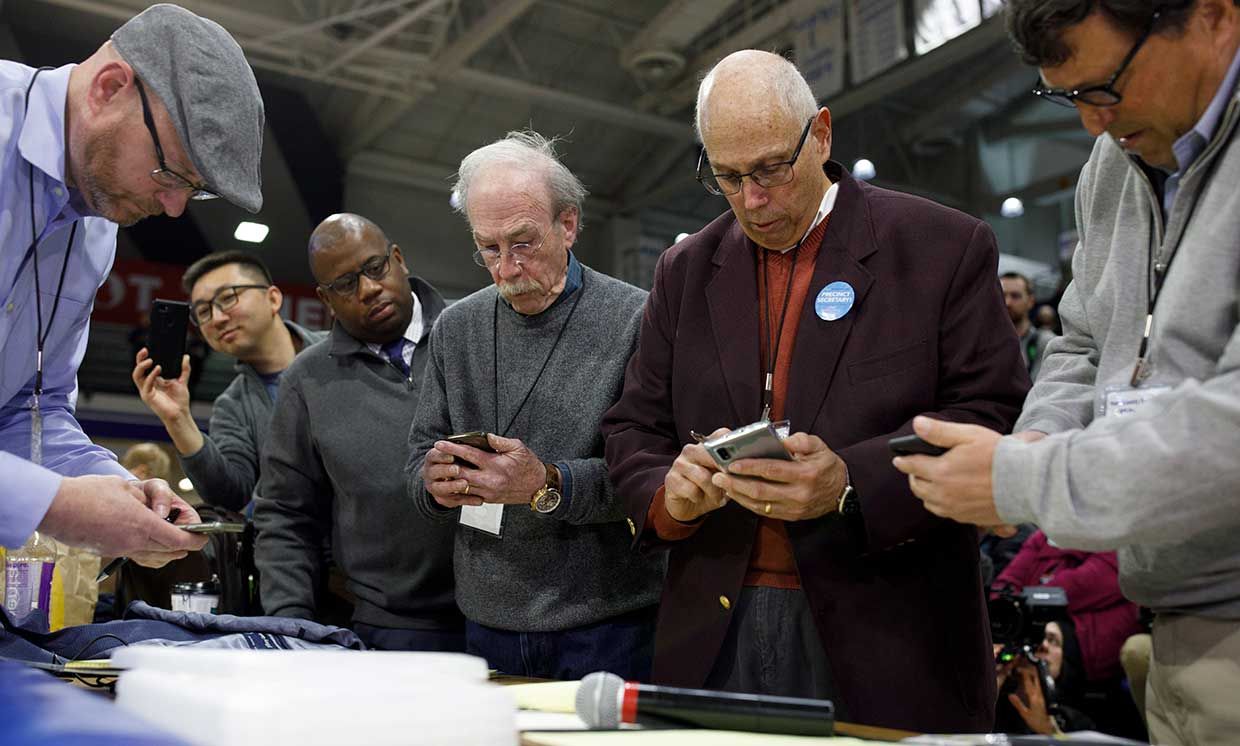 Officials from the 68th caucus precinct overlook the results of the first referendum count during a caucus event on February 3, 2020 at Drake University in Des Moines, Iowa, United States.