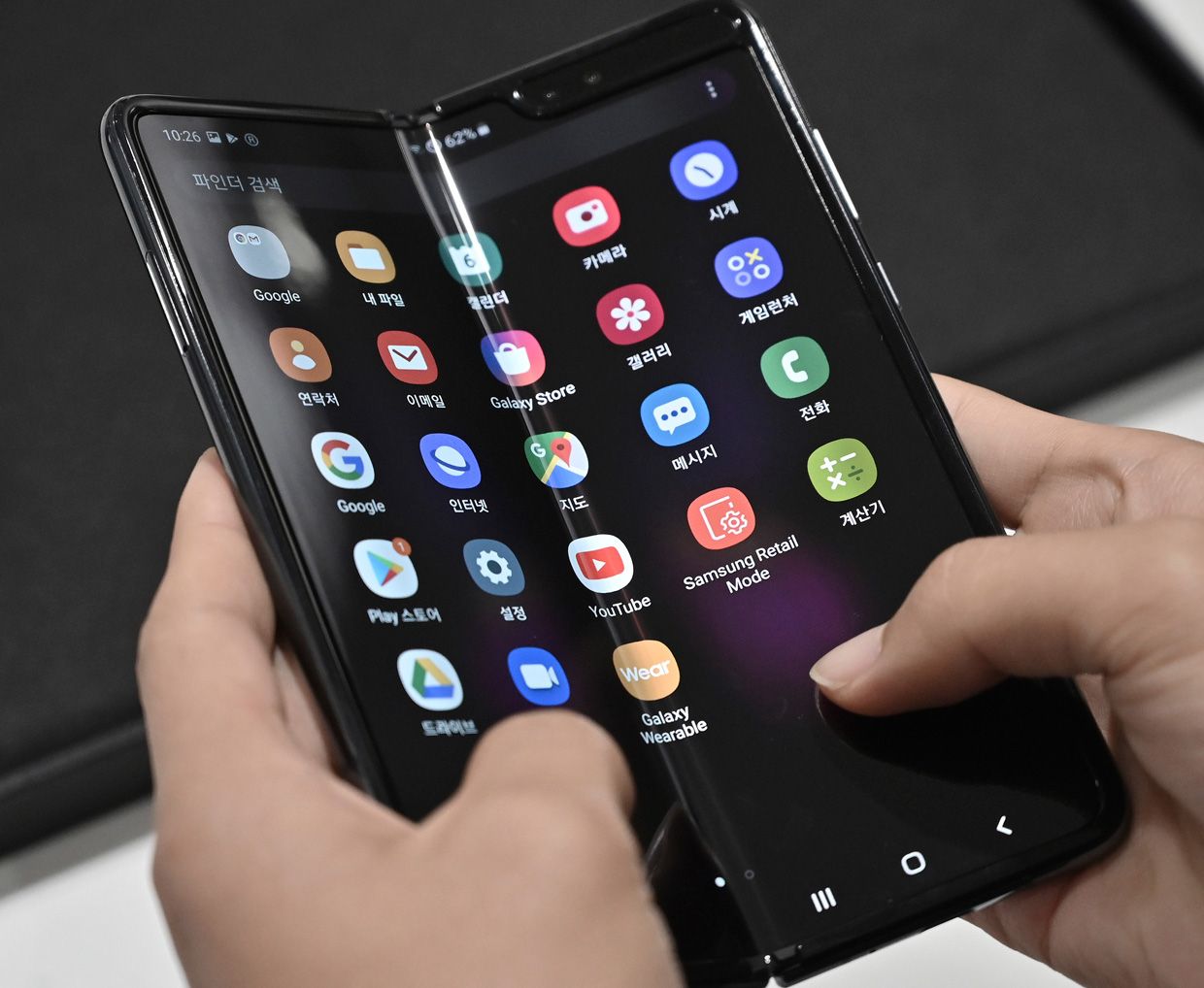 Person demonstrating the flexible display of the Samsung Galaxy Fold smartphone.
