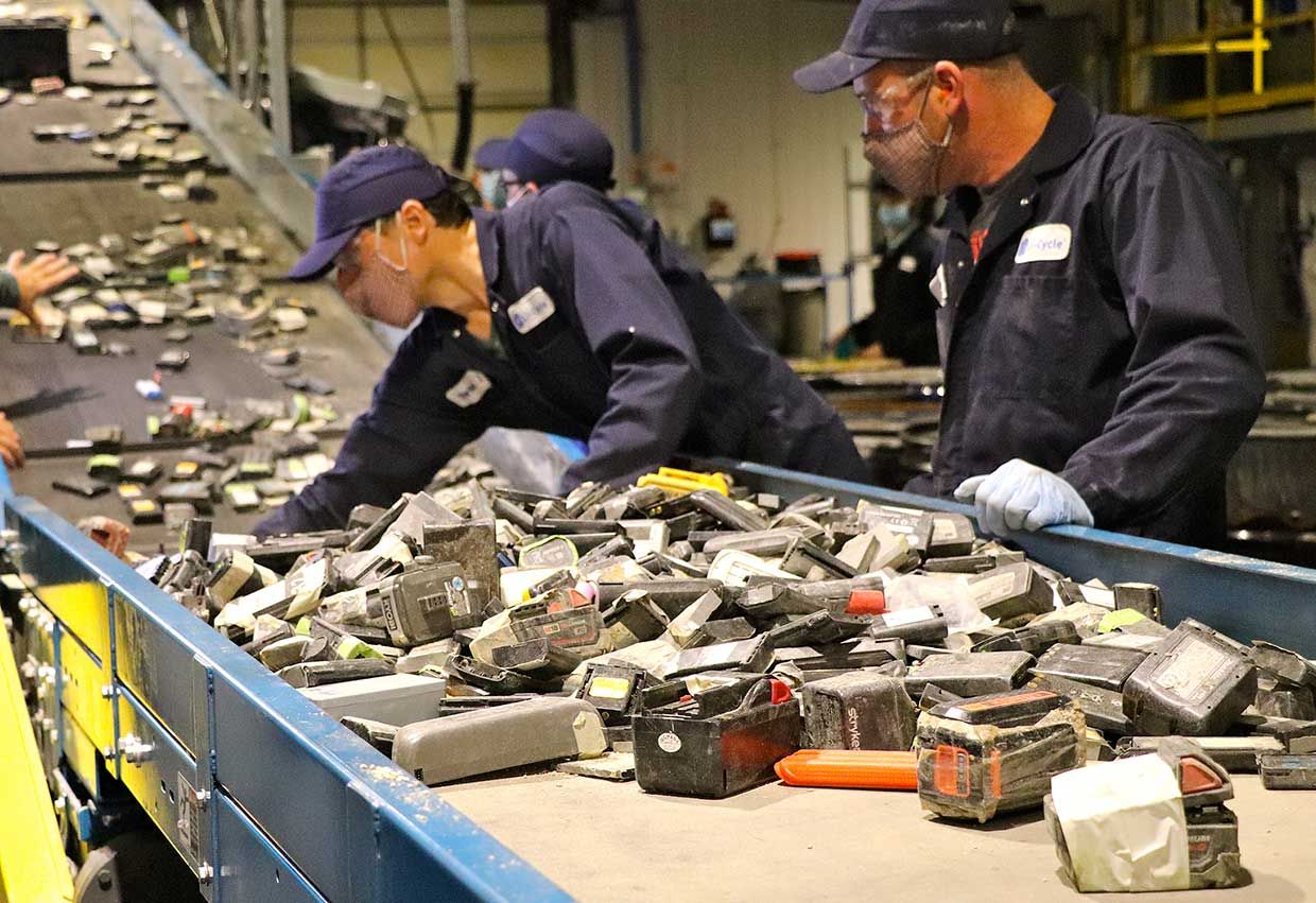 Workers sort lithium-ion batteries at Li-tsükkel's recycling facility near Toronto.