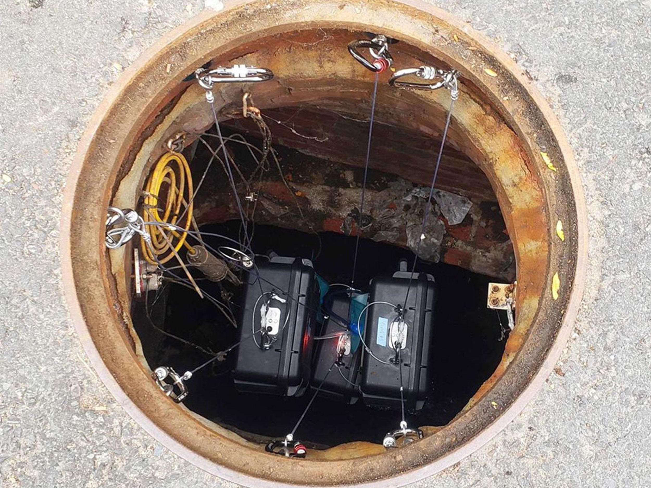 2019 photo of 3 Biobot Analytics robots in a sewer