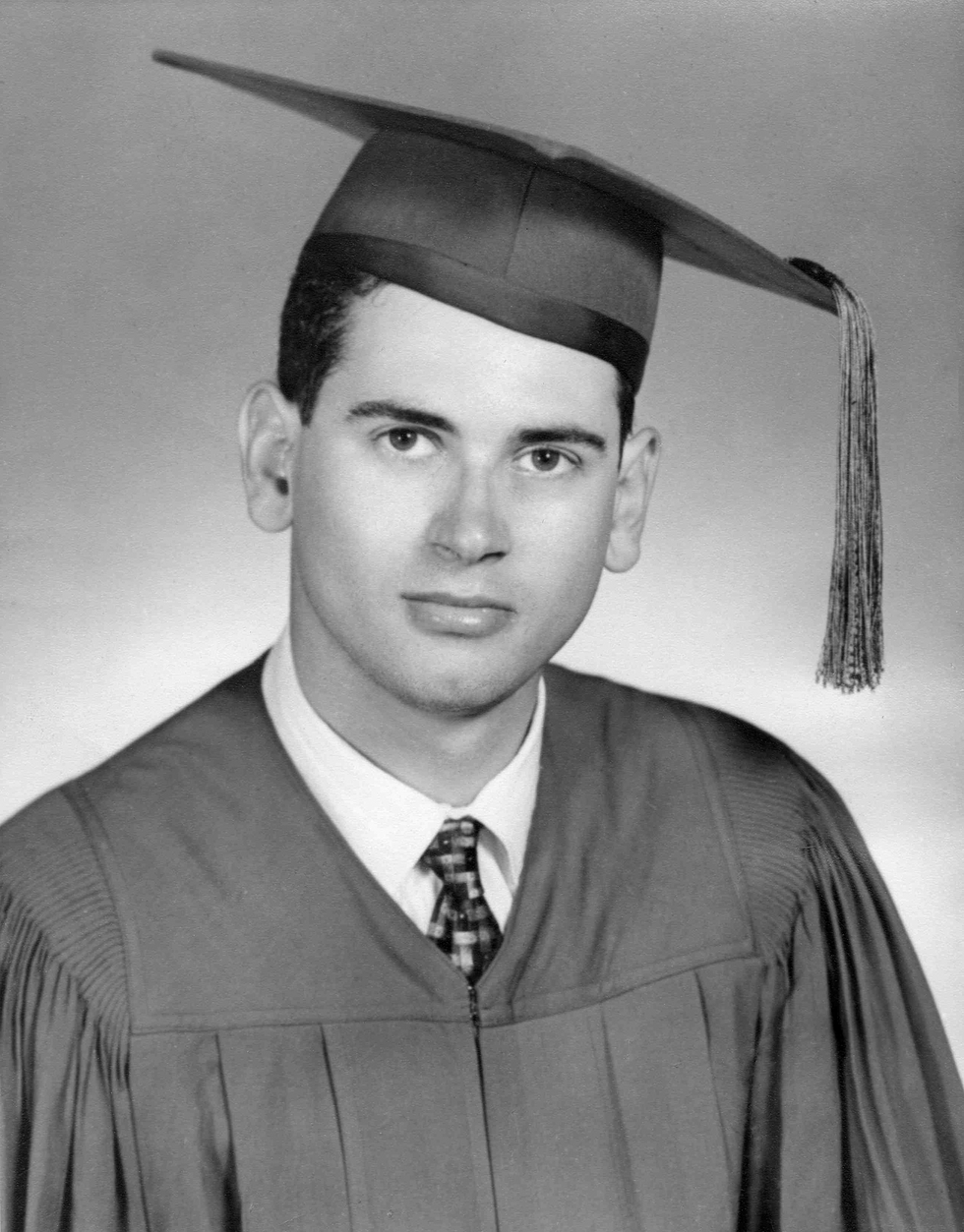 A black and white graduation portrait of a man in a cap and gown.