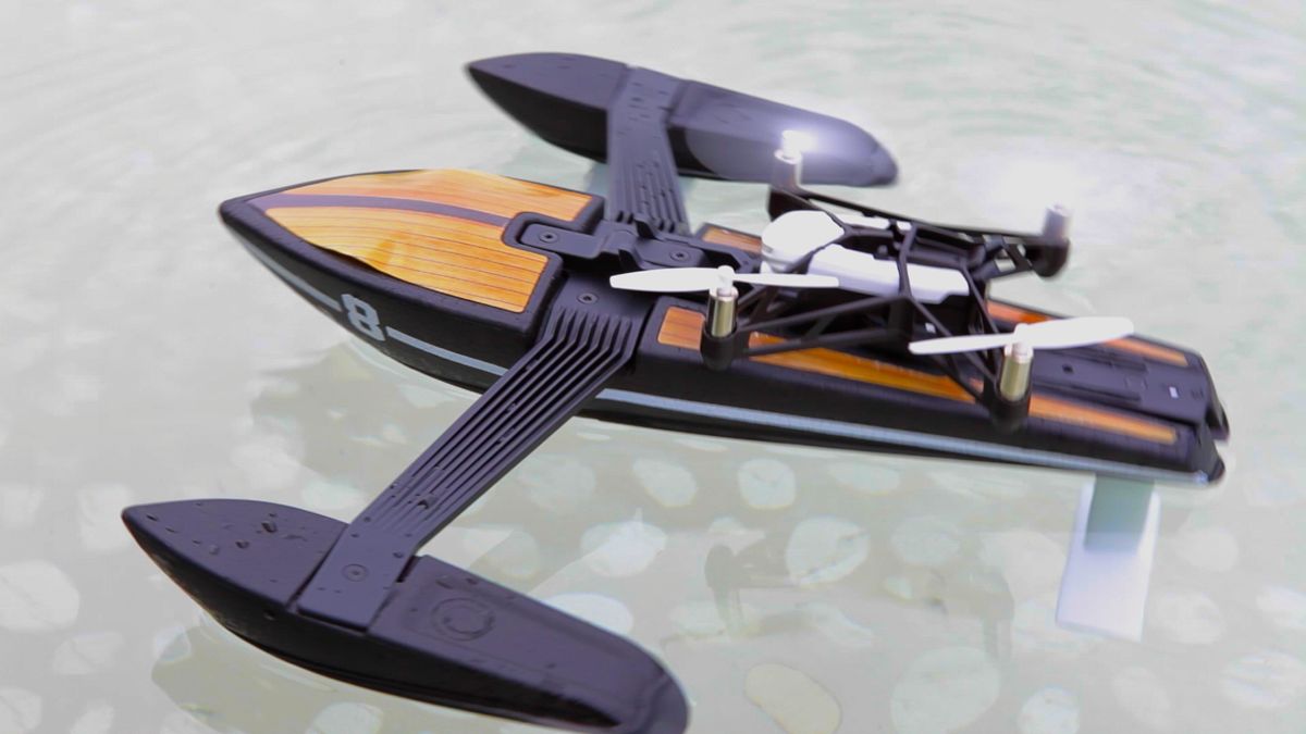 A cameraman-style boat floats in the water, with a quadcopter drone on top.
