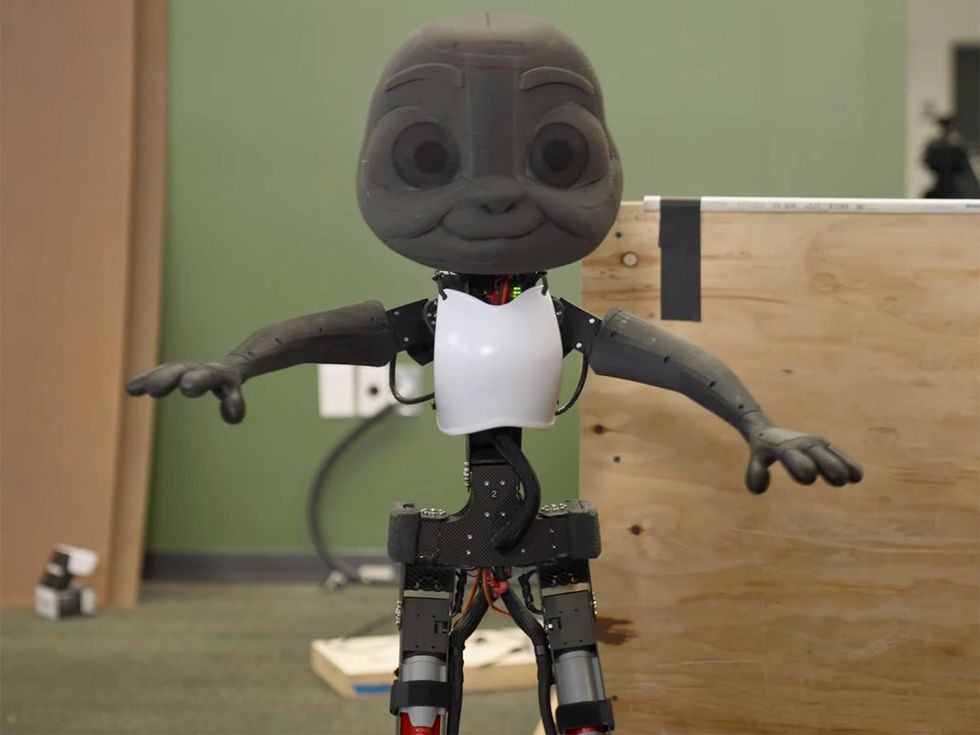 A cartoonish grey humanoid robot with its arms held out.