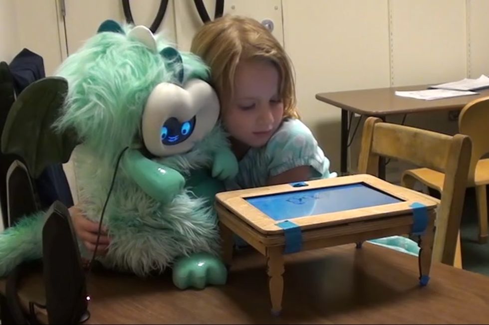 A child listens to DragonBot tell a story during one of our research studies.