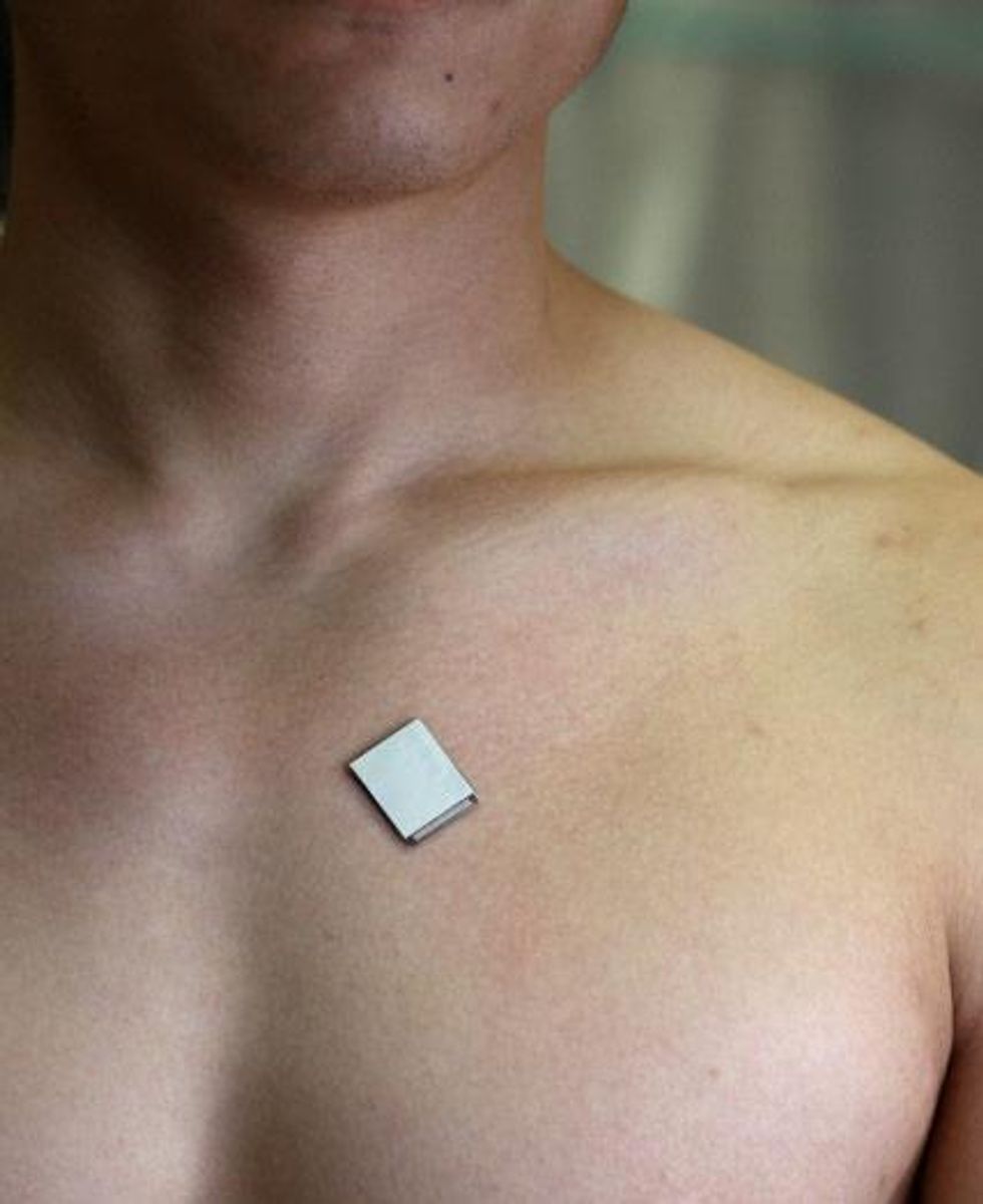 a close up photograph of a person's upper chest with a small white square attached to the skin