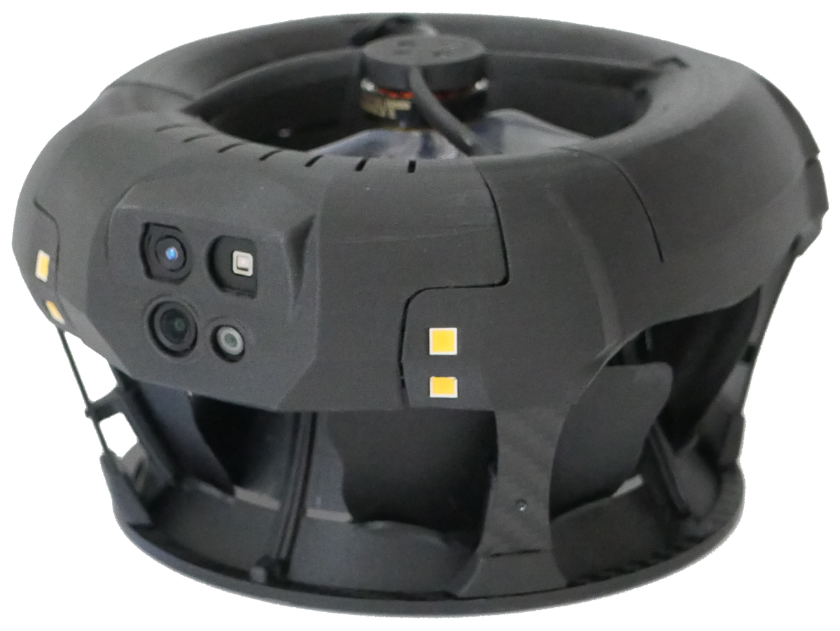 A close up picture of a small black drone which is round and flies with two internal ducted fans