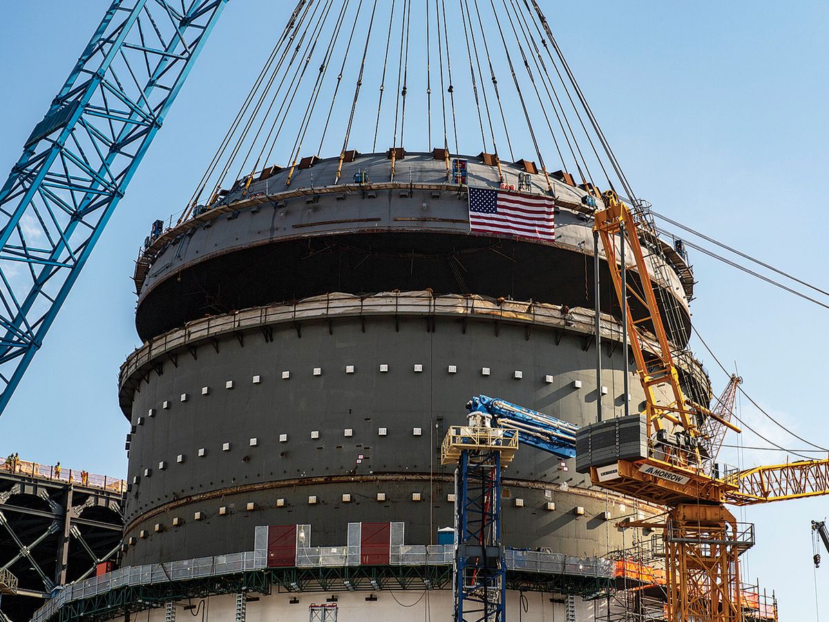 A crane lowers a heavy structure called a top head onto the Vogtle Unit 4 containment vessel in Georgia.