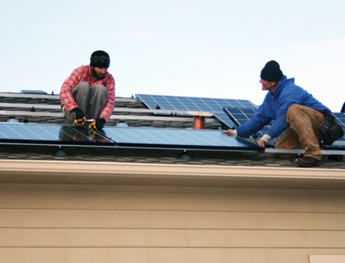 A crew from REC Solar installs solar panels on the roof of the author’s garage.