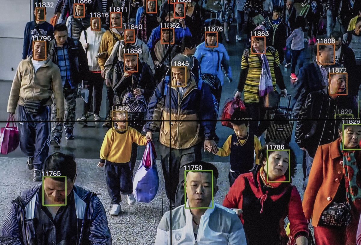 A crowd of people in China with overlays of facial recognition squares and numbers.