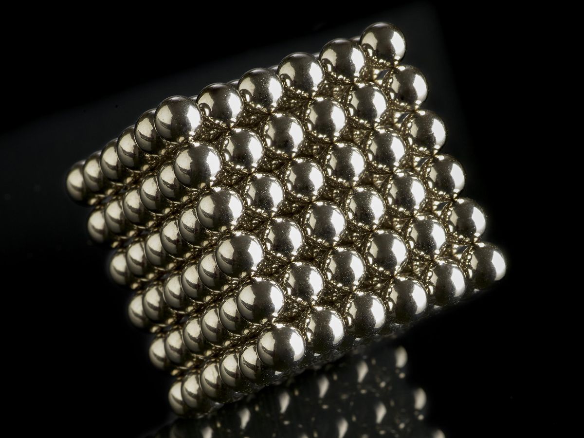 A cube made up of silver spheres.