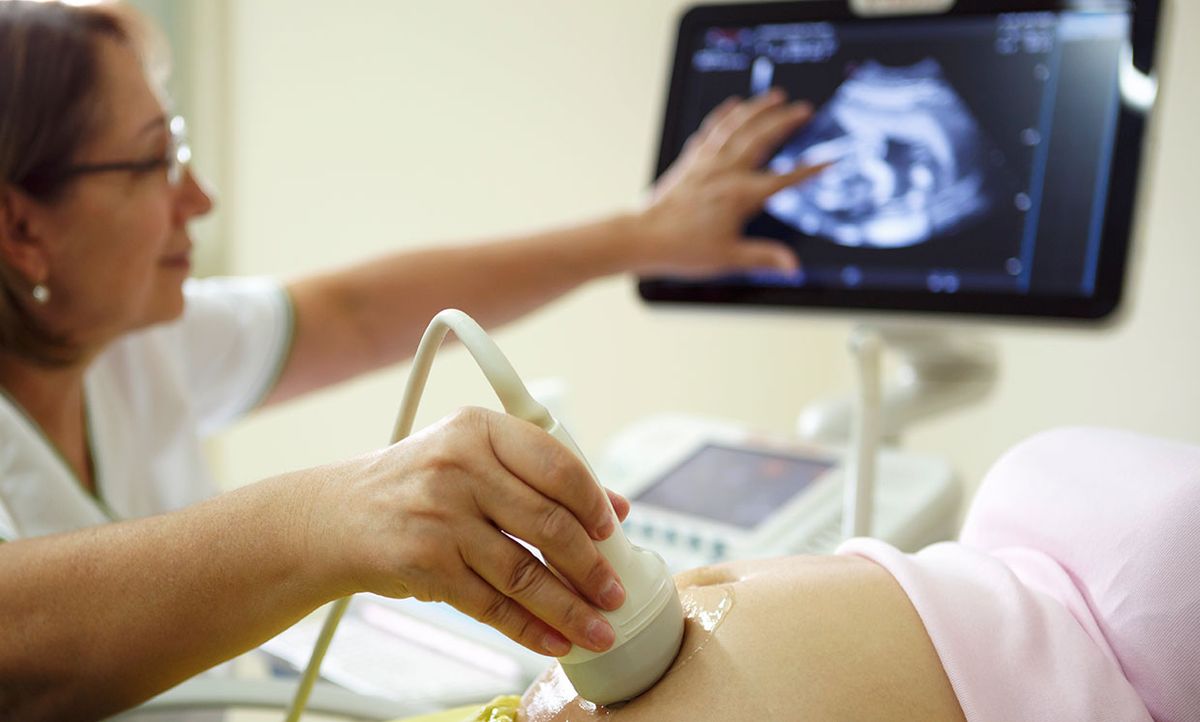 A doctor administers an ultrasound exam on a pregnant woman.
