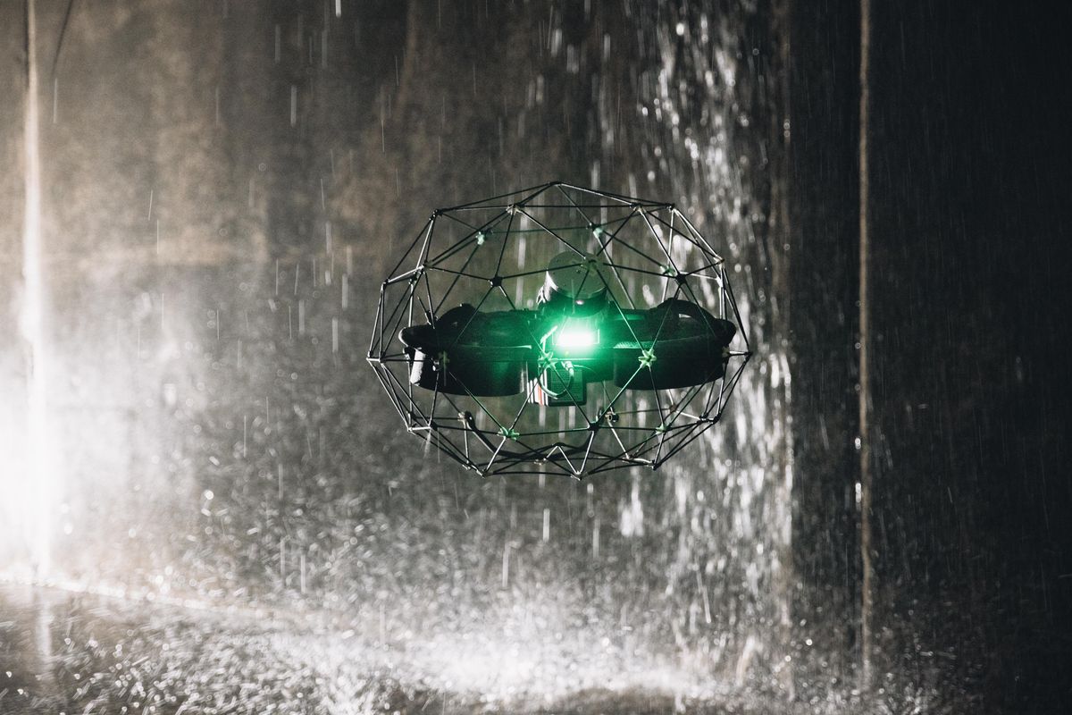 A drone inside of a protective geometric cage flies through a dark rain
