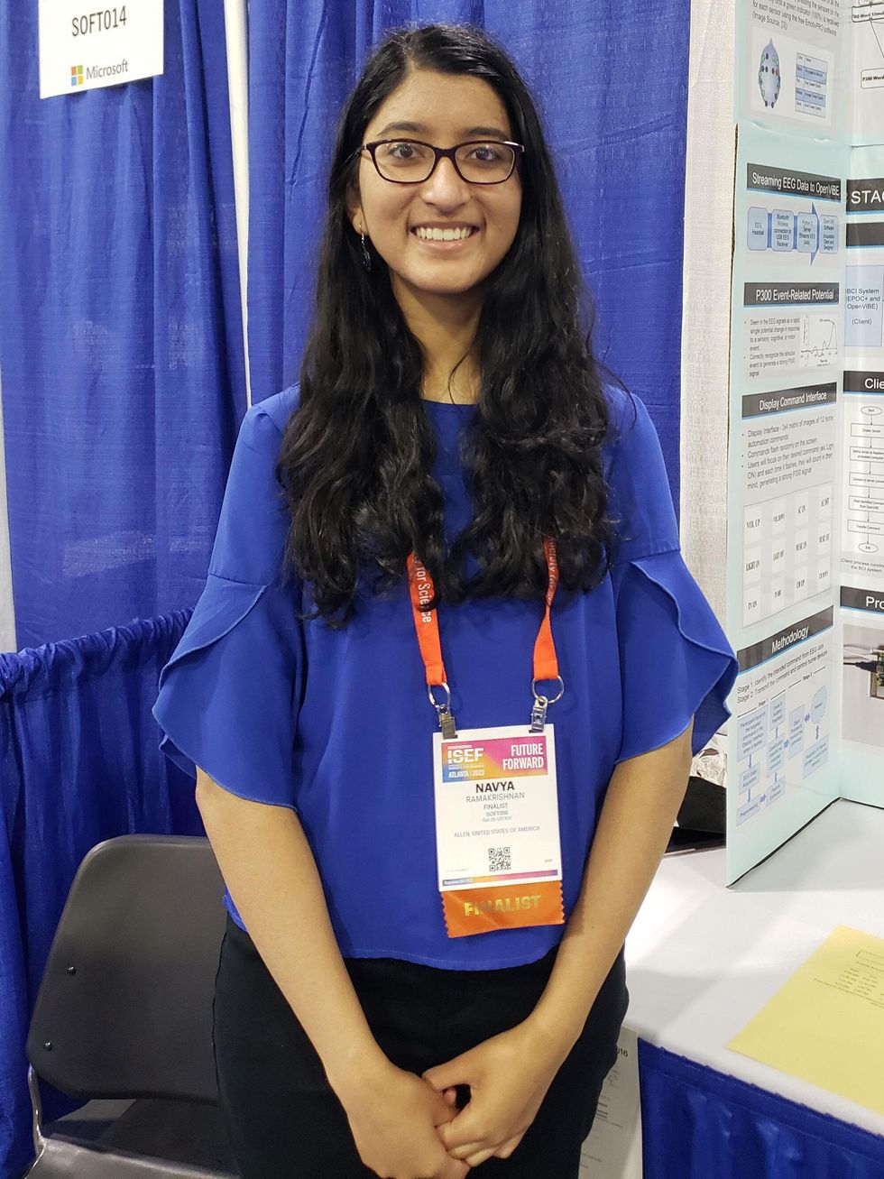 A female student wearing a lanyard identifying her as a finalist at ISEF.
