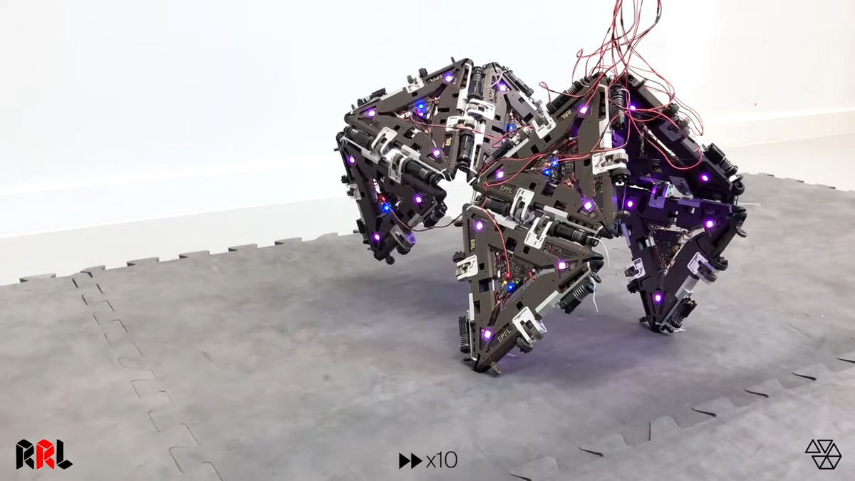 A four legged robot made entirely of interconnected triangular modules takes a slow step forward