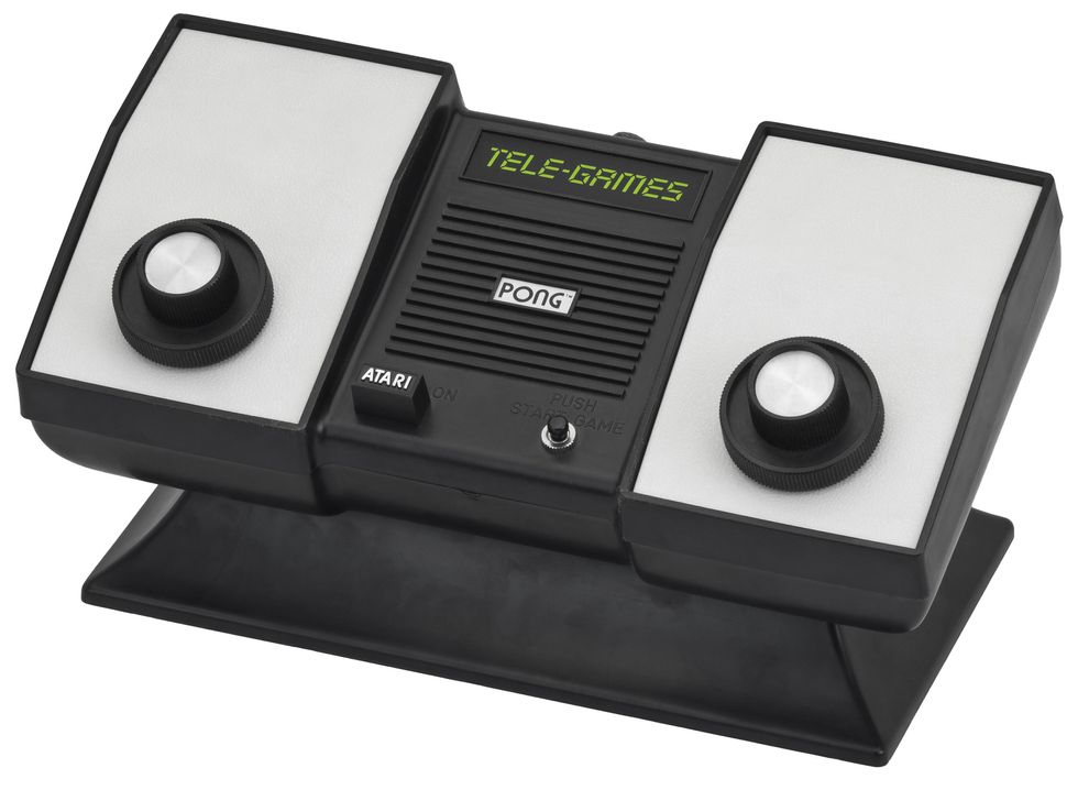 A game console for the video game Pong has two knobs and a digital readout that says Tele-Games.