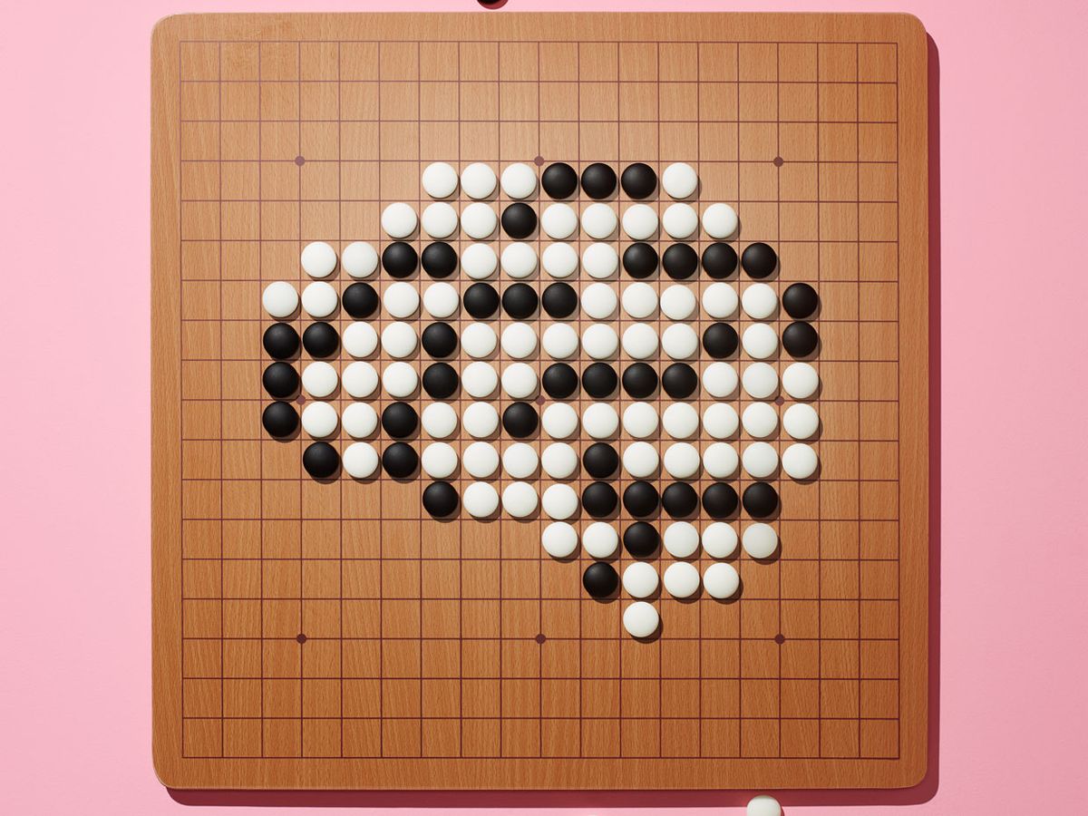 A Go board board covered with a grid of closely spaced lines and bean-size black and white stones.