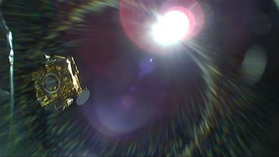 A golden cubesat with a bright light and lines