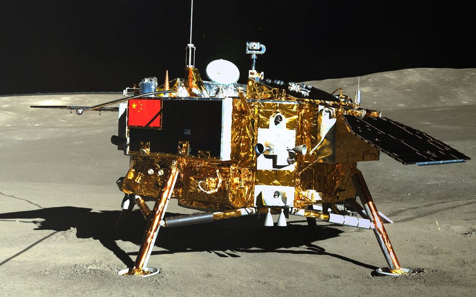 A golden lander with a solar panels, antennae, and a Chinese flag sits on the moon.