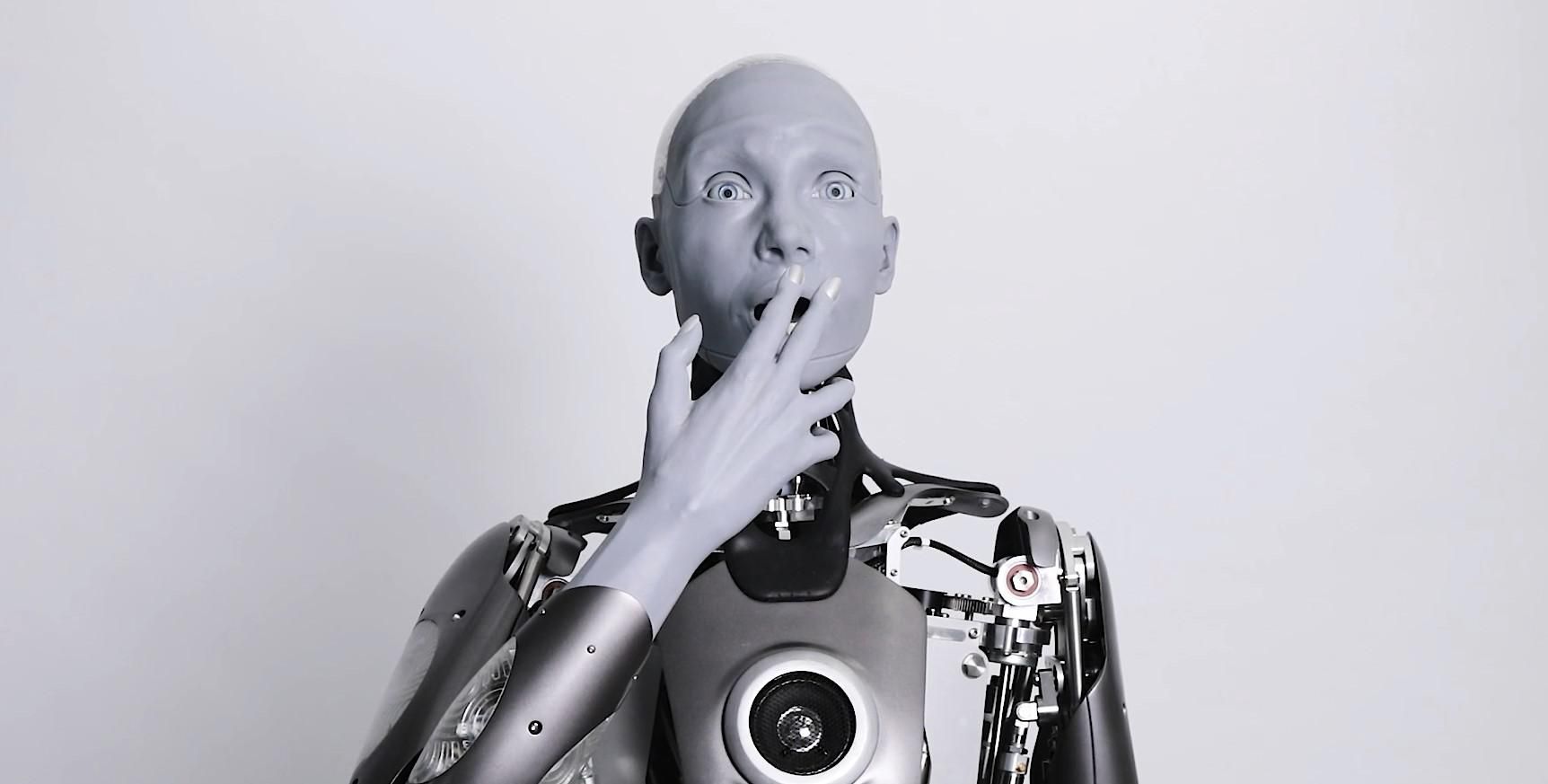 A gray anthropomorphic humanoid robot making an expression of surprise