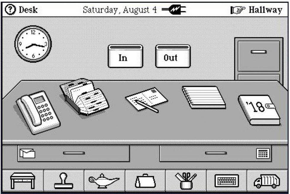 A grayscale graphical user interface shows a desktop with icons for a phone, Rolodex, calendar, and other common office implements. 