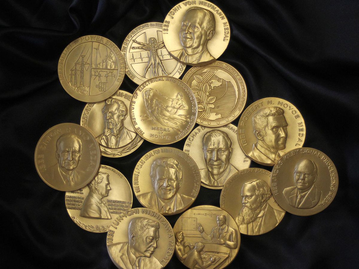 A group of gold IEEE Medals on black background.