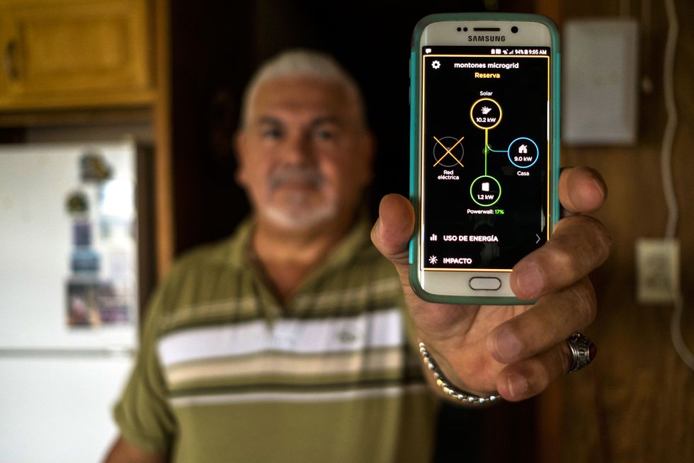 A homeowner uses his smartphone to monitor how much power his solar system is generating and how much electricity his household is consuming.