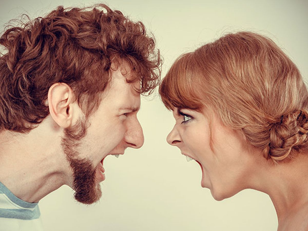 A man and a woman, face to face, yelling at each other.