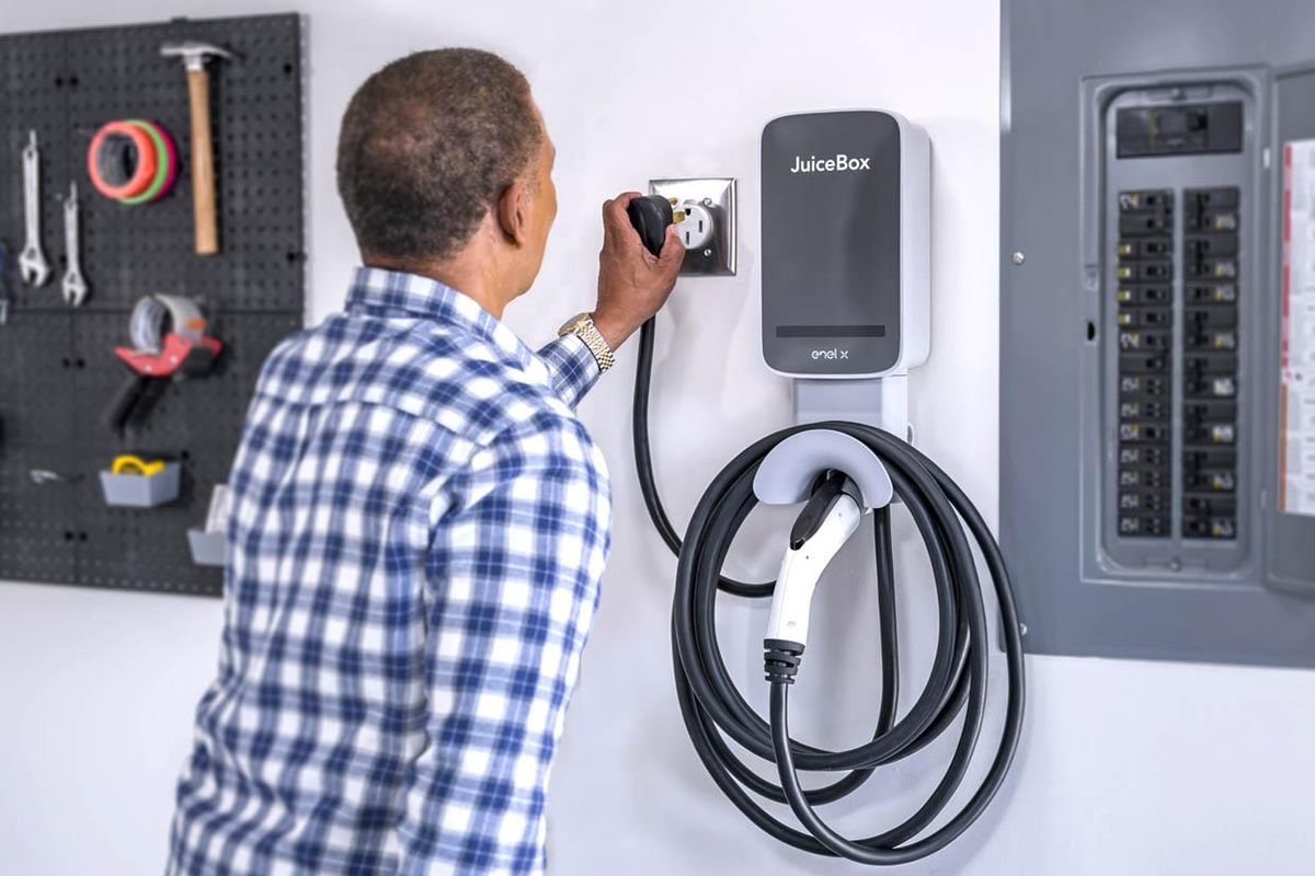 A man plugging a charger into an outlet