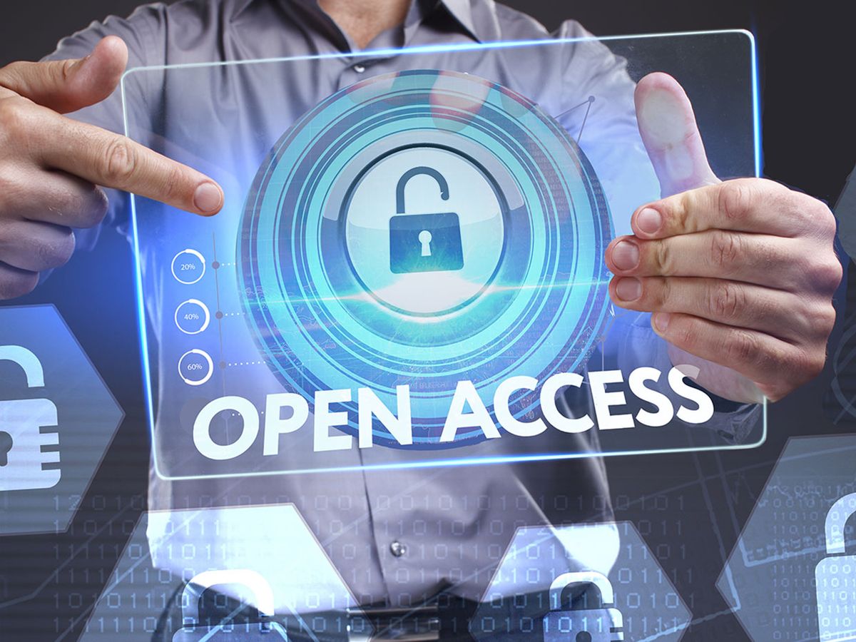 A man points to a clear tablet with the words open access and an unlocked lock icon on it.