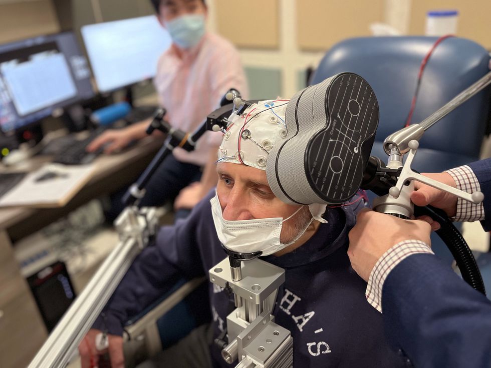a-man-sits-in-a-research-lab-with-an-eeg
