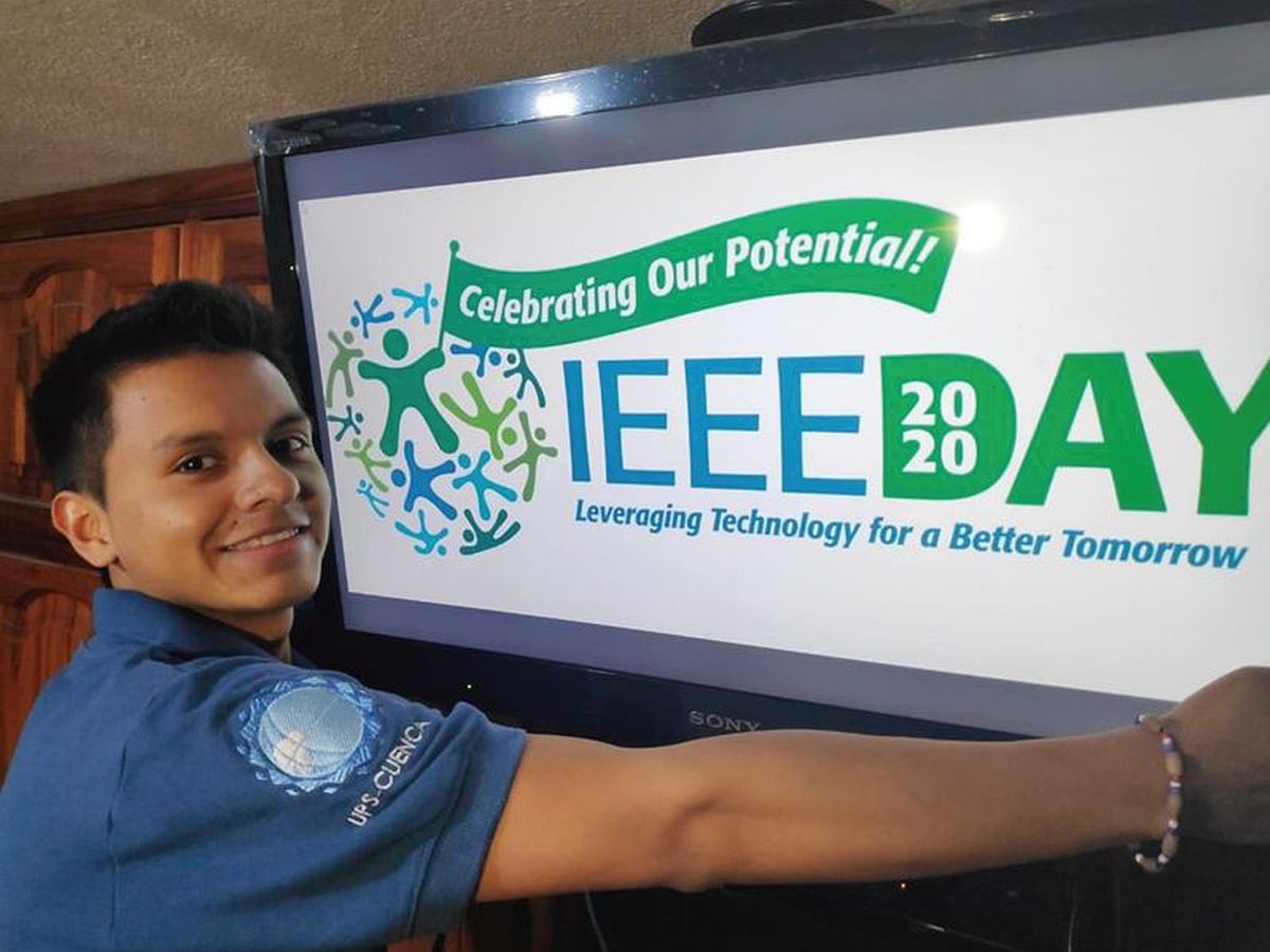 A man standing in front of a IEEE day sign.