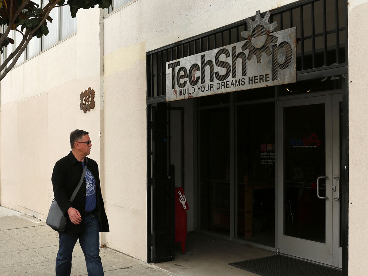 A man walks past the exterior of a building labelled TechShop in San Francisco, CA.