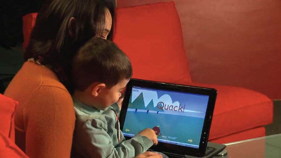 A mother reads a digital storybook with her child.