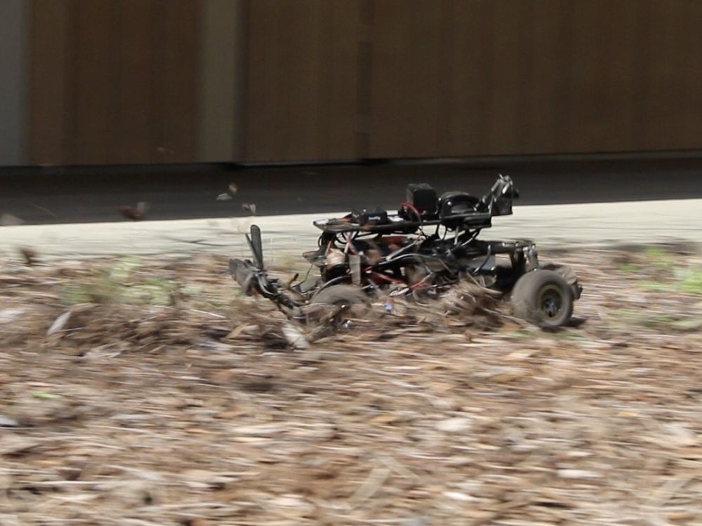 A motion blurred photo of a small autonomous race car speeding through leaves