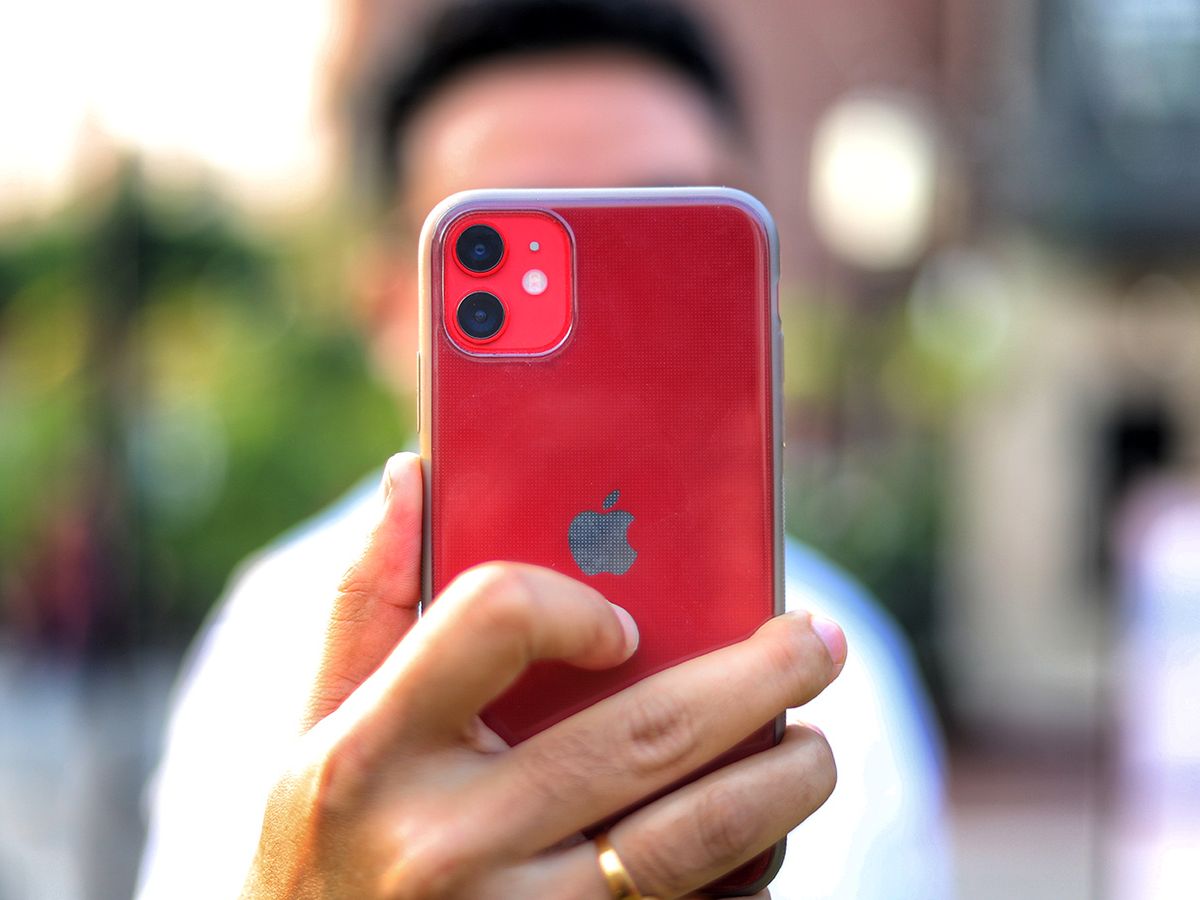 A person holds up a red iPhone to the camera.