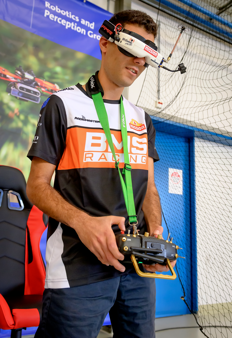 A person wearing goggles and holding a set of remote controls.