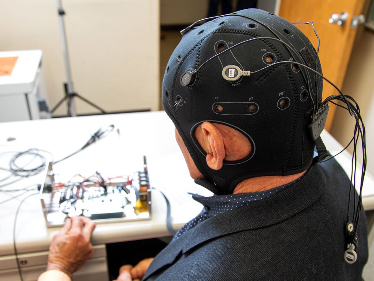 A person wears a black cap with electrodes to measure the effects of electrical stimulation on the brain