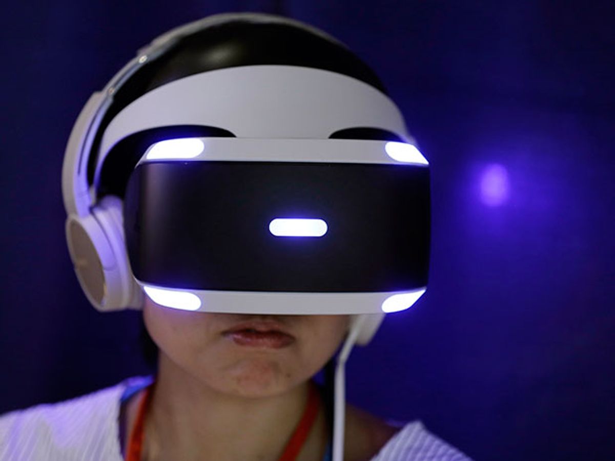 A person wears a white-and-black Sony PlayStation VR headset to play a video game during a launch event in Tokyo, Japan.