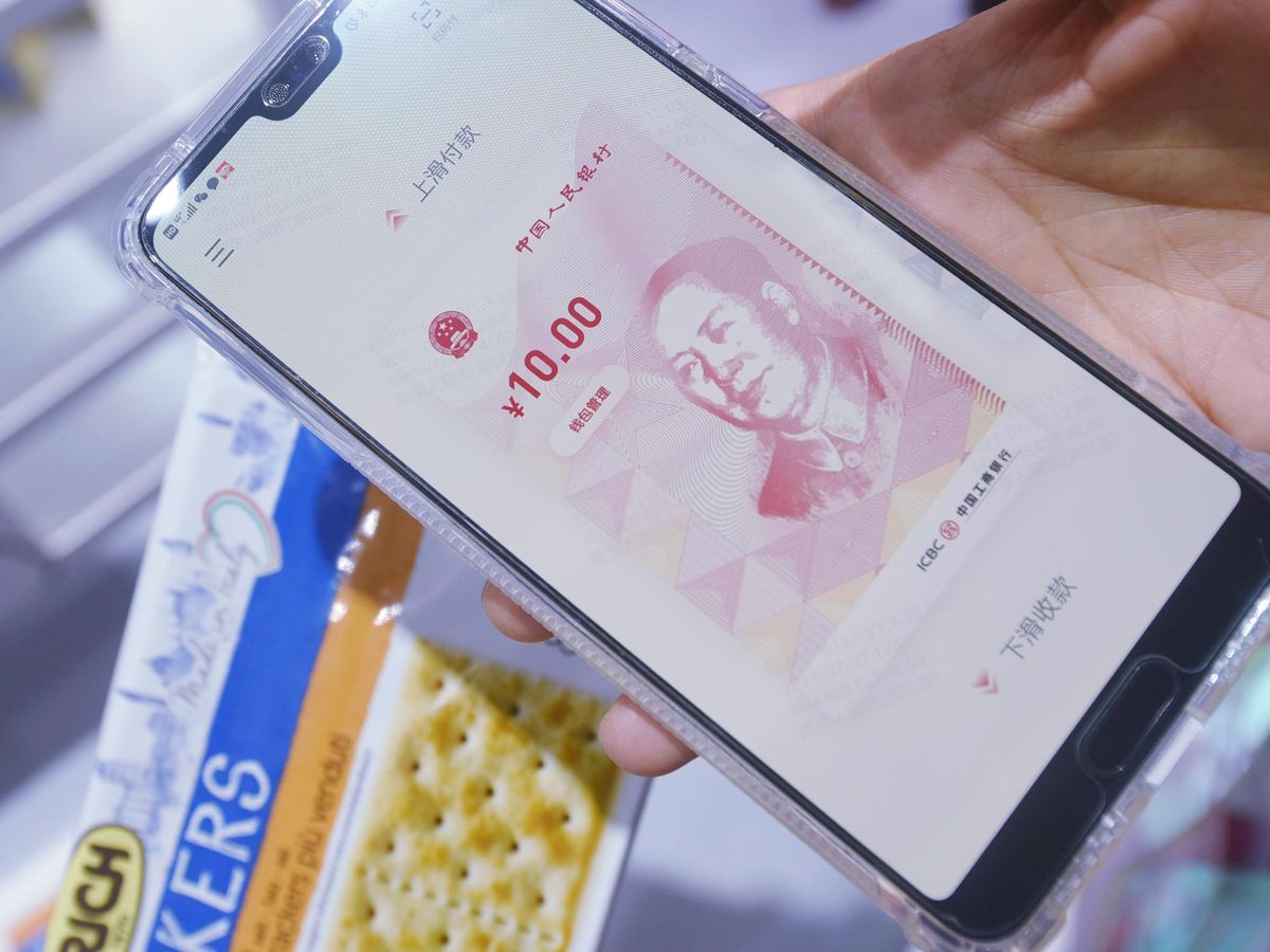 A phone with an image of the Chinese 10.00 Yuan hovers over a package of crackers.