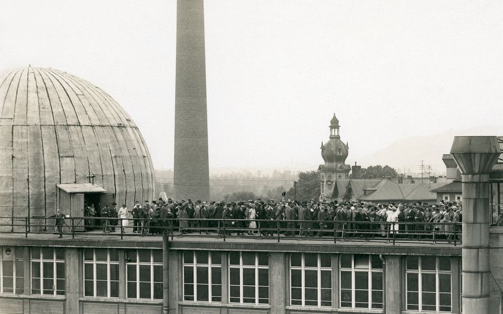 A photo of a crowd of people on the roof on a building.