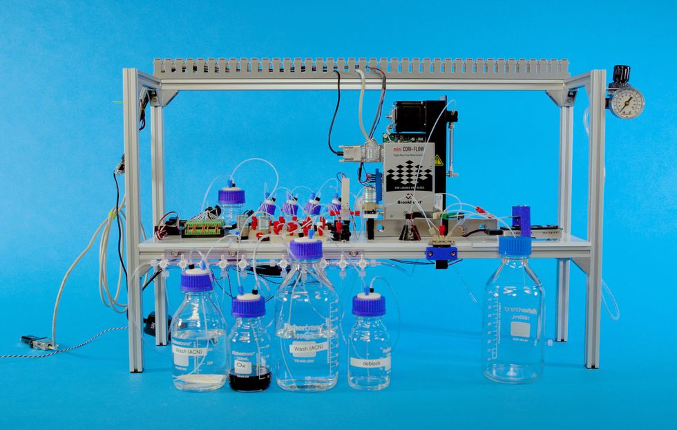 A photo of a device with bottles in front of a blue background.