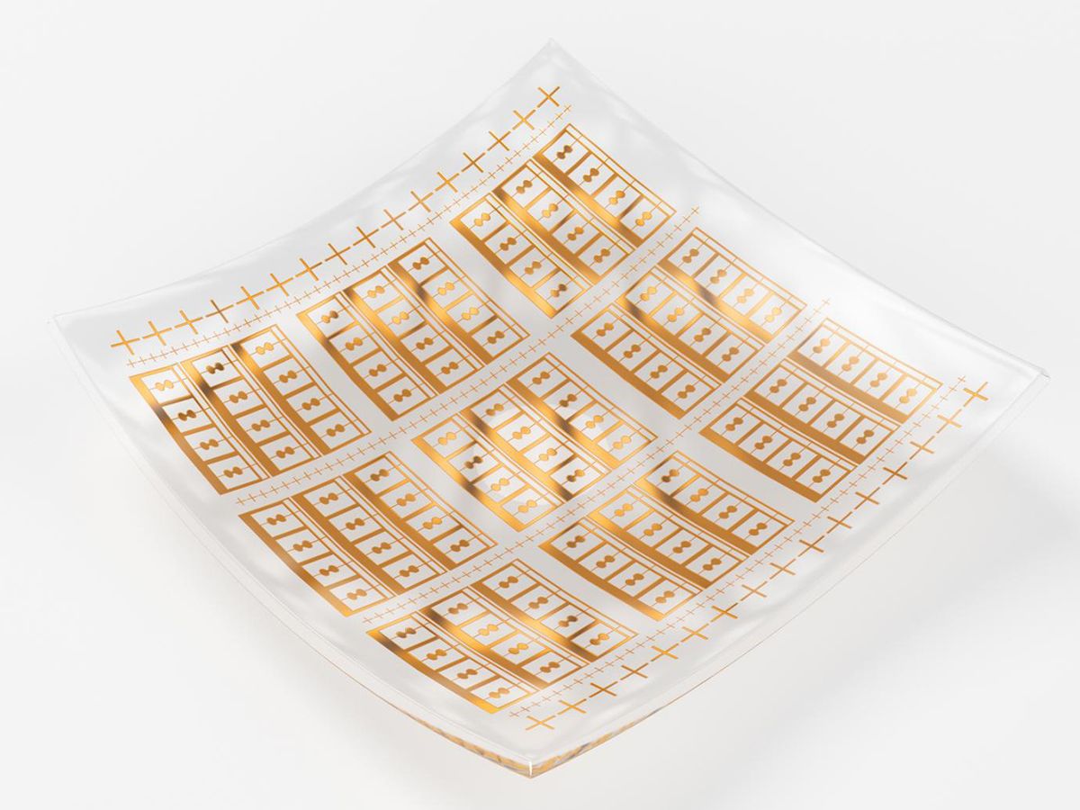 A photo of a flexible terahertz detector which looks like a transparent square with a pattern of boxes and grids etched onto it in gold. 